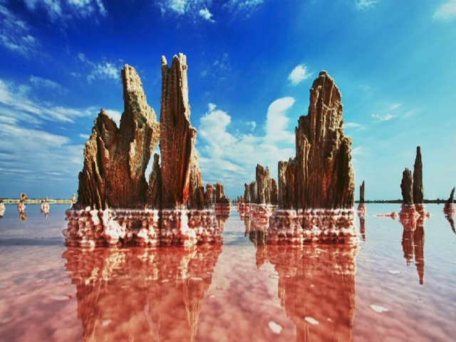  Озеро Сасык-Сиваш . Сасык-Сиваш расположено недалеко от Евпатории, на Крымском полуострове. Его отличают не только целебные грязи и особая соль, обладающая массой полезных веществ, но также и удивительный розовый цвет водной глади. Ранее это озеро было мелким заливом, но в результате штормов постепенно возникла песчаная дамба, перекрывшая выход к морю. Сейчас оно занимает площадь в 75 300 м². Максимальная глубина его составляет 1,2 метра. Именно эта его особенность привлекает к себе туристов с детьми. Они могут спокойно купаться там всей семьей. А на его берегах возникли 2 крупных курортных города – Саки и Евпатория. 