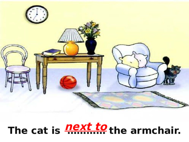 next to  The cat is ………… the armchair. 